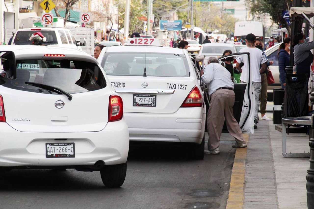 Un taxi sube pasaje en una calle de la ciudad