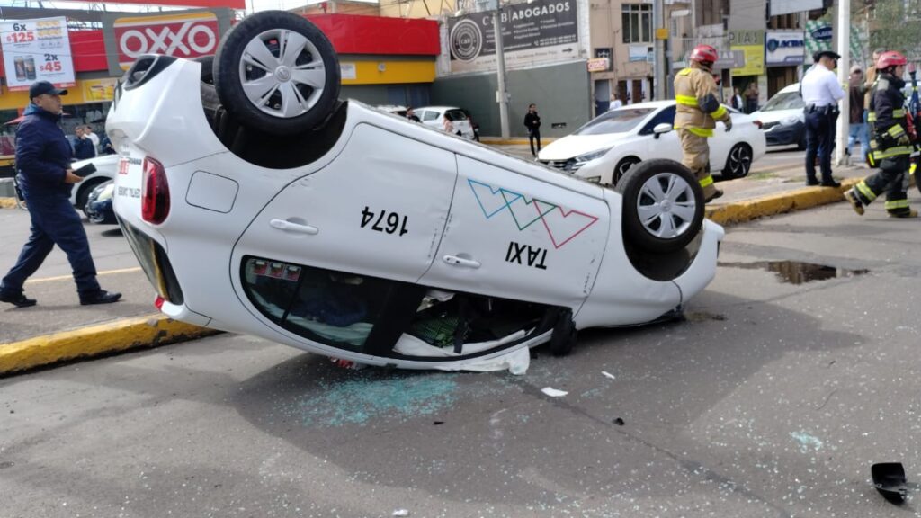 Aparatoso accidente en la glorieta del Quijote deja taxi volcado sobre su toldo